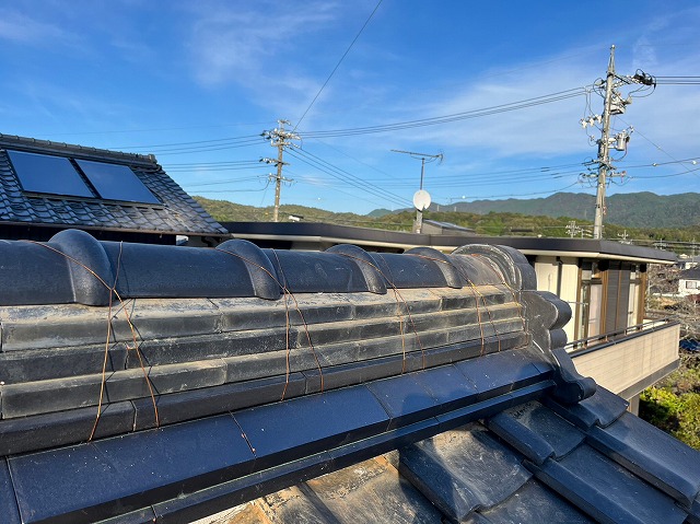 棟瓦を積み替え工事で整え、銅線でしっかり固定された完成後の棟。まっすぐに美しく仕上がり、防水性と耐風性が向上した状態を写した写真。