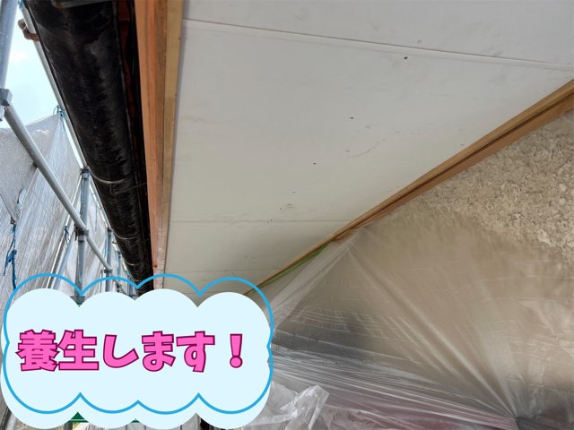 軒天塗装前に外壁や雨樋を養生シートで覆い、塗料の飛散を防いでいる様子