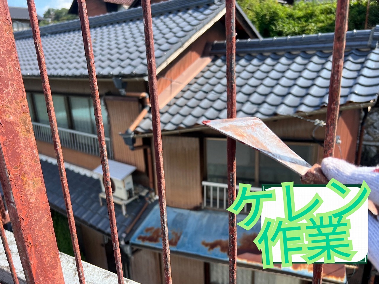 手摺の錆をヘラで削り落としているケレン作業の様子
