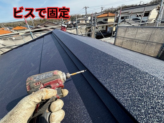 可児市緑ヶ丘にて棟板金をビスで取り付け施工の様子