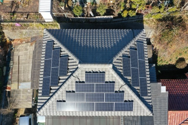 上空から見た寄棟構造の瓦屋根全景。屋根全体にソーラーパネルが設置されている様子