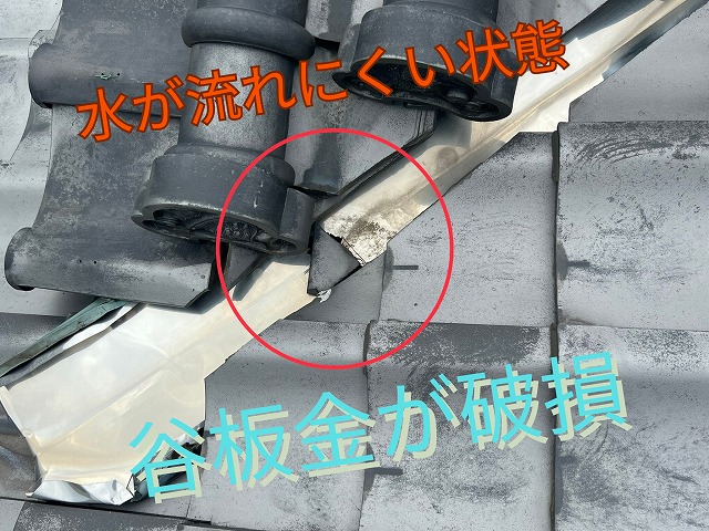 谷板金が破損し、水の流れが妨げられている様子