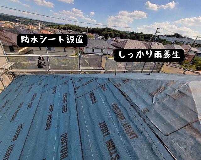 屋根全面に防水シート「カスタムライト」を敷設している様子。青いシートが屋根を覆っている。