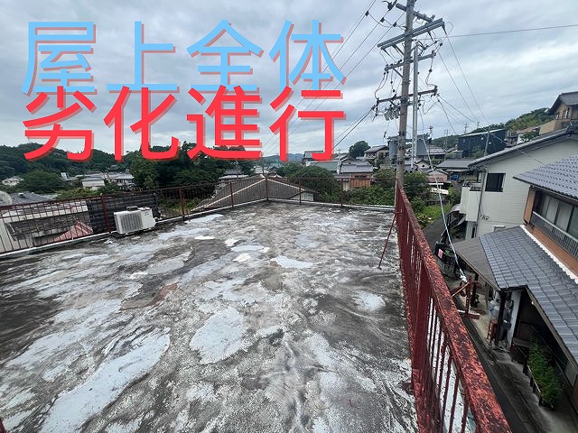 屋上全体が劣化し、表面の防水材が剥がれ補修跡が多数残っている