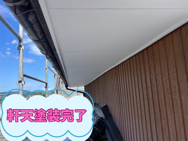青空の下、全体が真っ白に塗り替えられた軒天塗装の完成写真