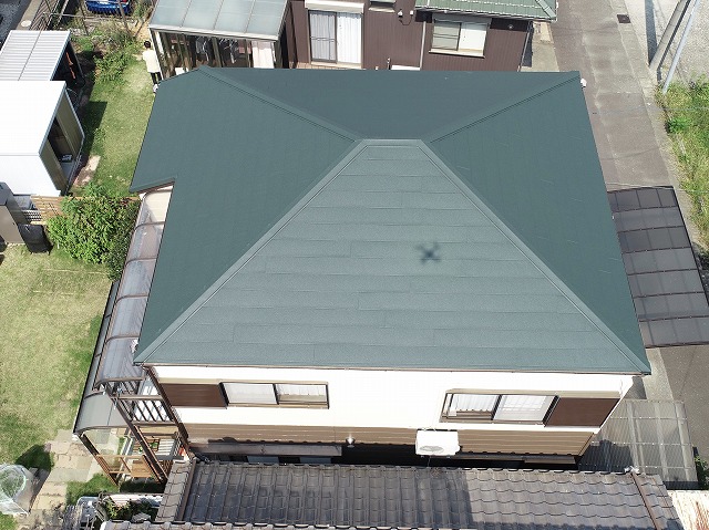 カバー工事完了後の屋根をドローンで撮影した写真。スーパーガルテクト（シェイドグリーン）が美しく葺かれ、凹凸もなく滑らかで新築のような仕上がり。