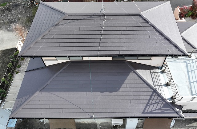 屋根カバー工事と雨樋交換工事が完了した可児市土田のお住まいを上空から撮影した写真。屋根全体がきれいに仕上がり、統一感のある外観になっている。