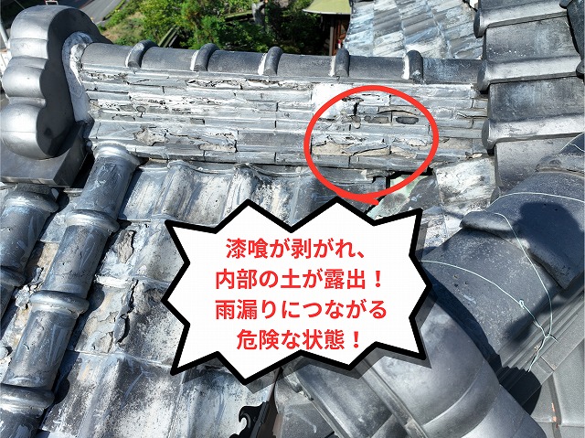 棟瓦の下の漆喰が剥がれ、内部の土が露出している様子