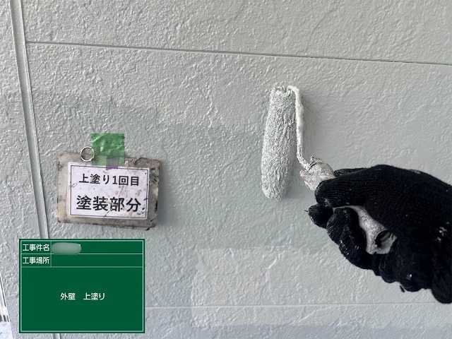 瑞浪市明世町の住宅で外壁の上塗りを行っている様子