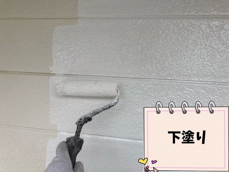 春日井市坂下町の外壁に下塗り塗料を施工している様子