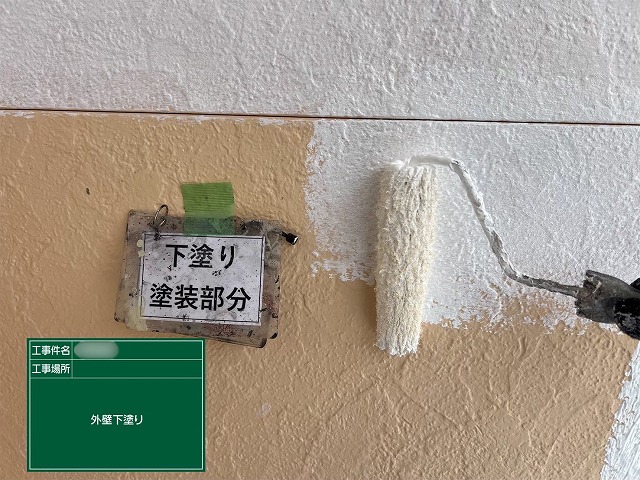 瑞浪市明世町の住宅で外壁に下塗り塗料を塗布している様子