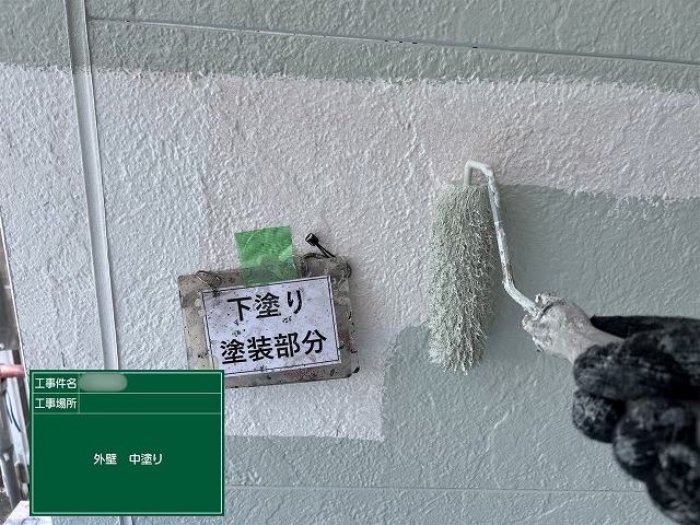 瑞浪市明世町の住宅で外壁の中塗りを行っている様子