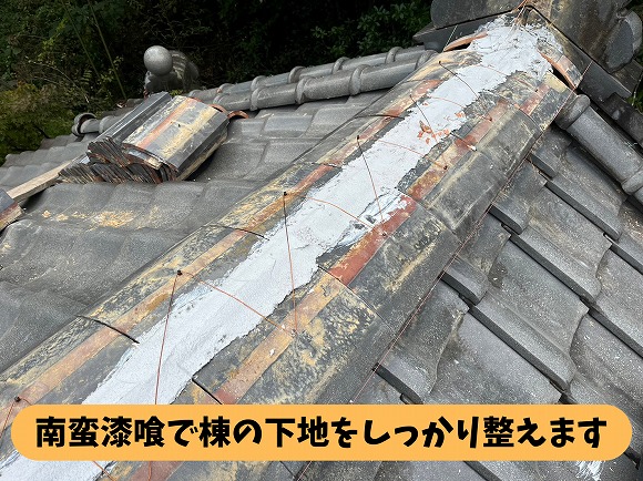 瓦屋根の棟部分に南蛮漆喰を施工し、下地を整えている様子