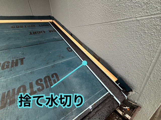 名古屋市にて1階玄関屋根の壁際に捨て水切りを施工する様子