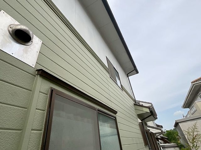 外壁塗装工事前の多治見市脇之島町の住宅。グリーンの外壁に色あせが見られ、全体的にメンテナンスが必要な状態