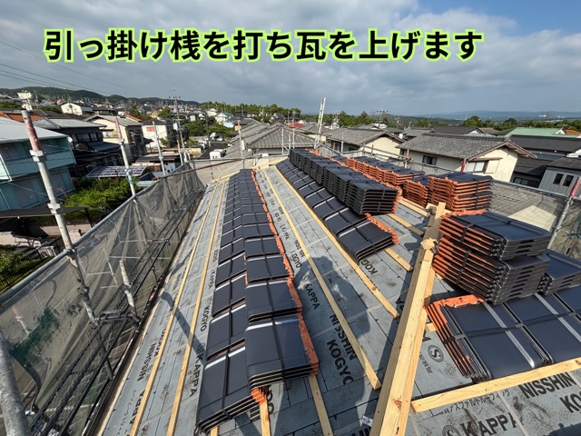 多治見市小名田町にて桟木を施工し、瓦を屋根へ上げている様子