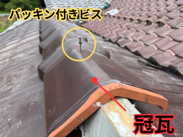 美濃加茂市にて冠瓦を取り付け、パッキンビスで固定している様子