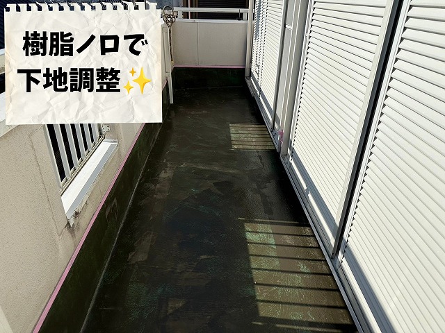 可児市桜ケ丘で樹脂ノロを施工し防水下地を平滑に整えている様子