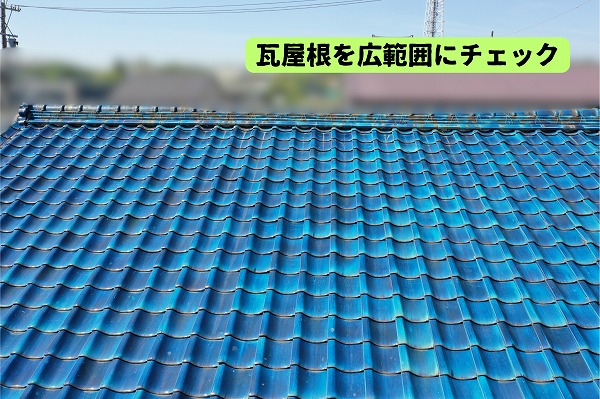 美濃加茂市の住宅にある青い瓦屋根と棟の状態を確認している様子