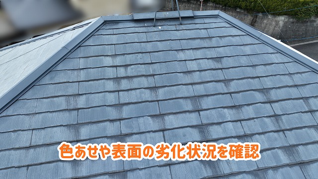 美濃加茂市の住宅にあるスレート屋根の色あせや表面の状態を確認した様子